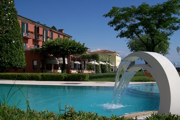Una piscina al aire libre, sillones reclinables de piscina