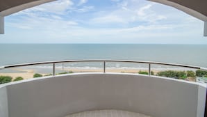 A balcony with a curved railing overlooking a beach and the sea. - Golden Beach Cha-Am Hotel (Cha-am)