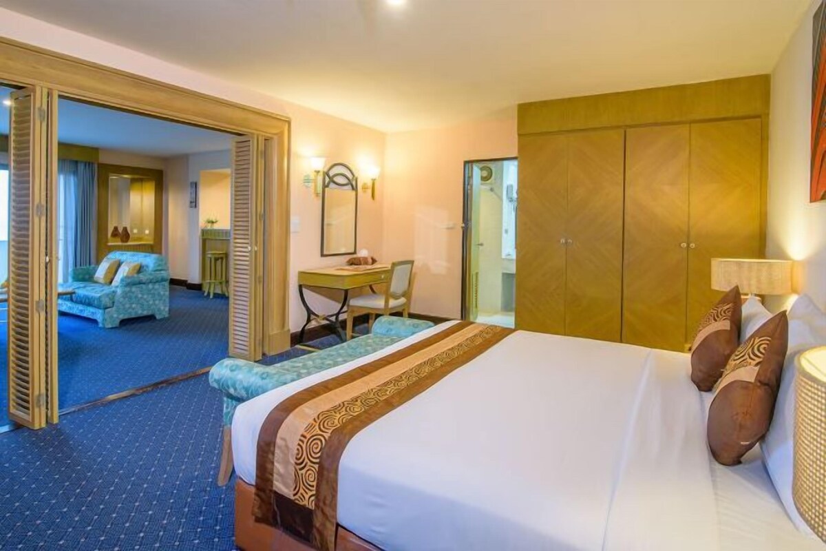 Una habitación de hotel con una cama grande, un escritorio y un armario.