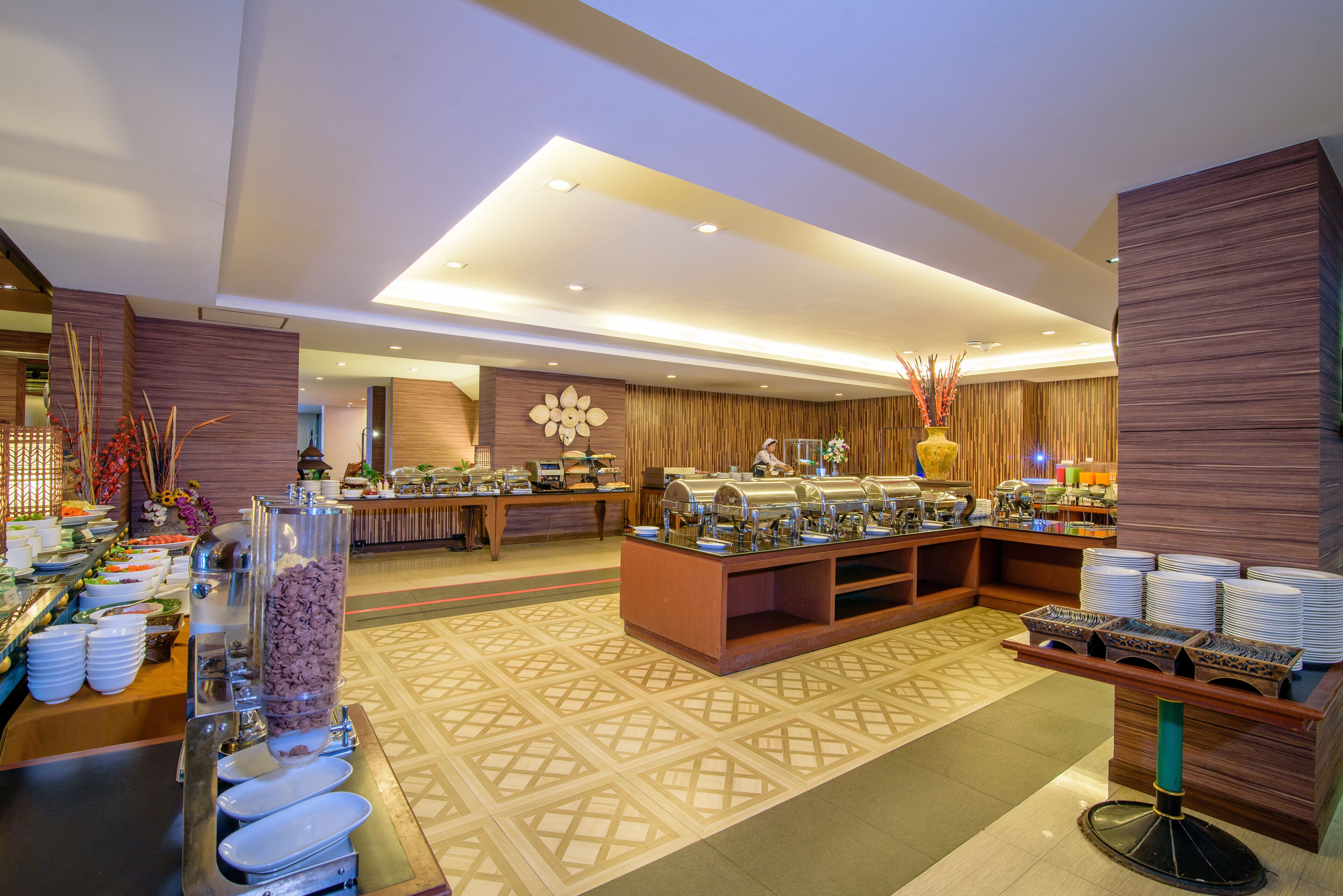 A buffet area with multiple food stations, a central serving counter, and a patterned floor.
