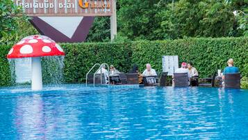 Een buitenzwembad, parasols bij het zwembad en ligstoelen