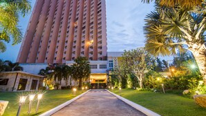 A tall hotel with a central entrance, surrounded by well-maintained greenery and pathways. - Golden Beach Cha-Am Hotel (Cha-am)