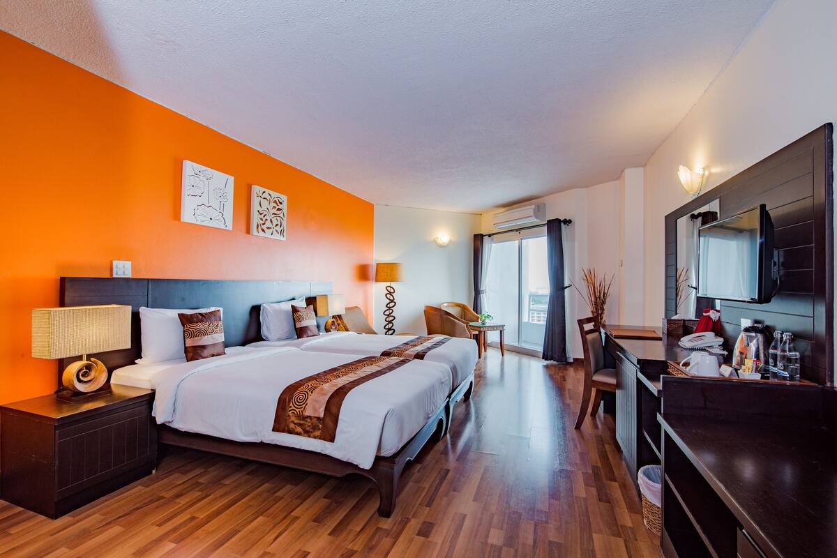 Een hotelkamer met een groot bed, een bureau, een stoel en een televisie.