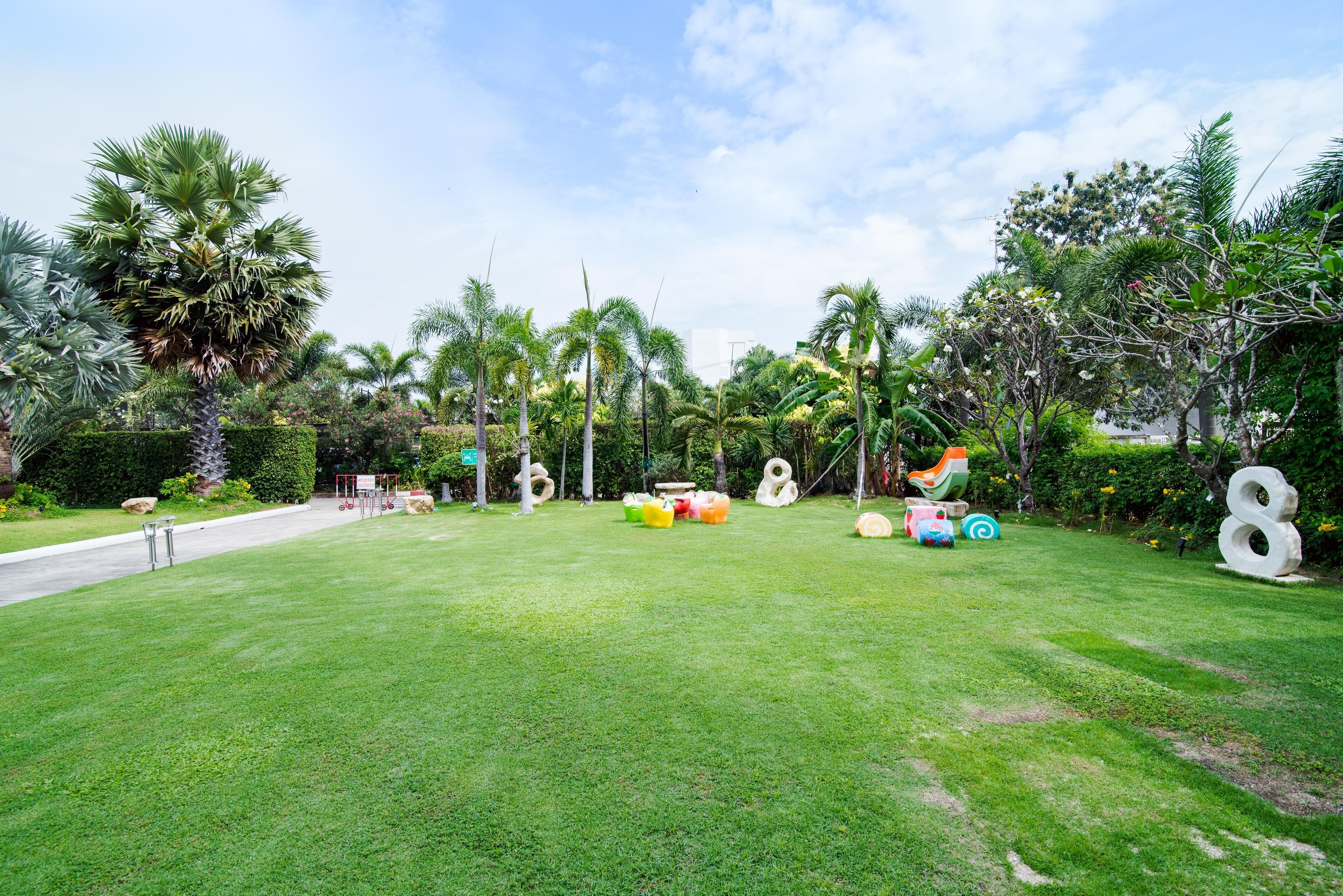 Un jardín bien cuidado con diversas plantas tropicales y estructuras de juego coloridas.