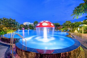 Una piscina al aire libre, sombrillas, sillones reclinables de piscina