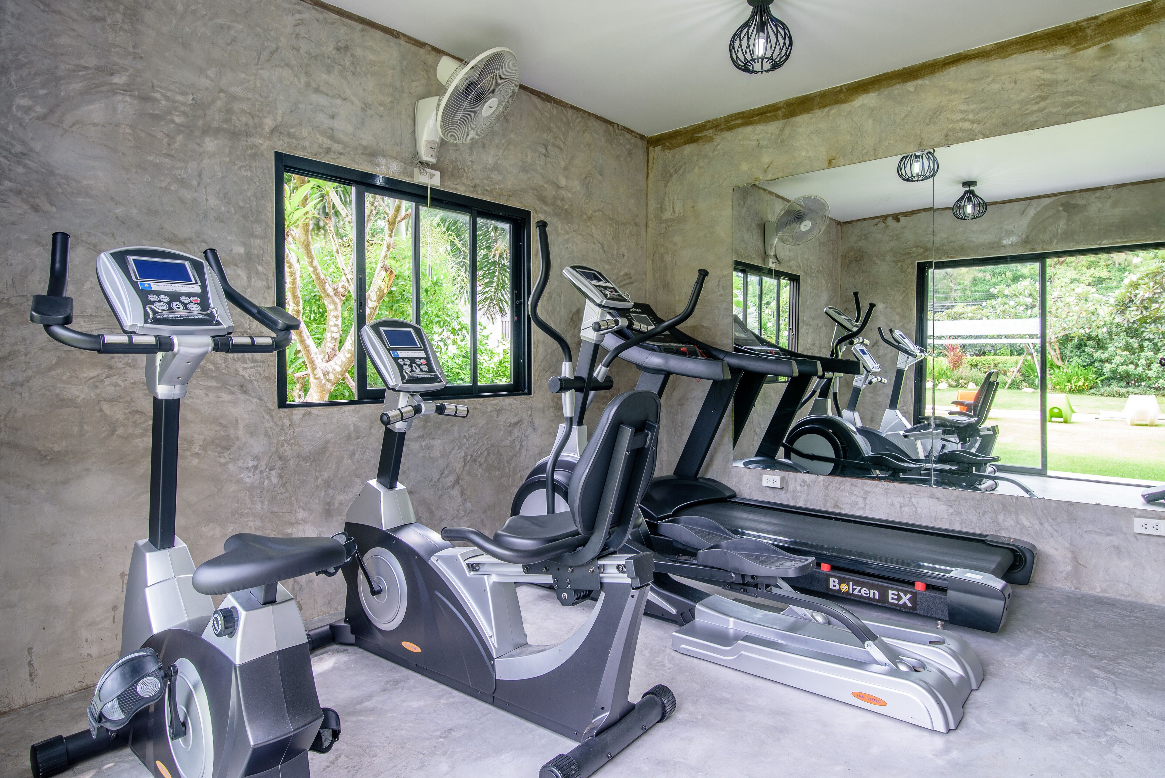 A gym with stationary bikes, treadmills, and a rowing machine.