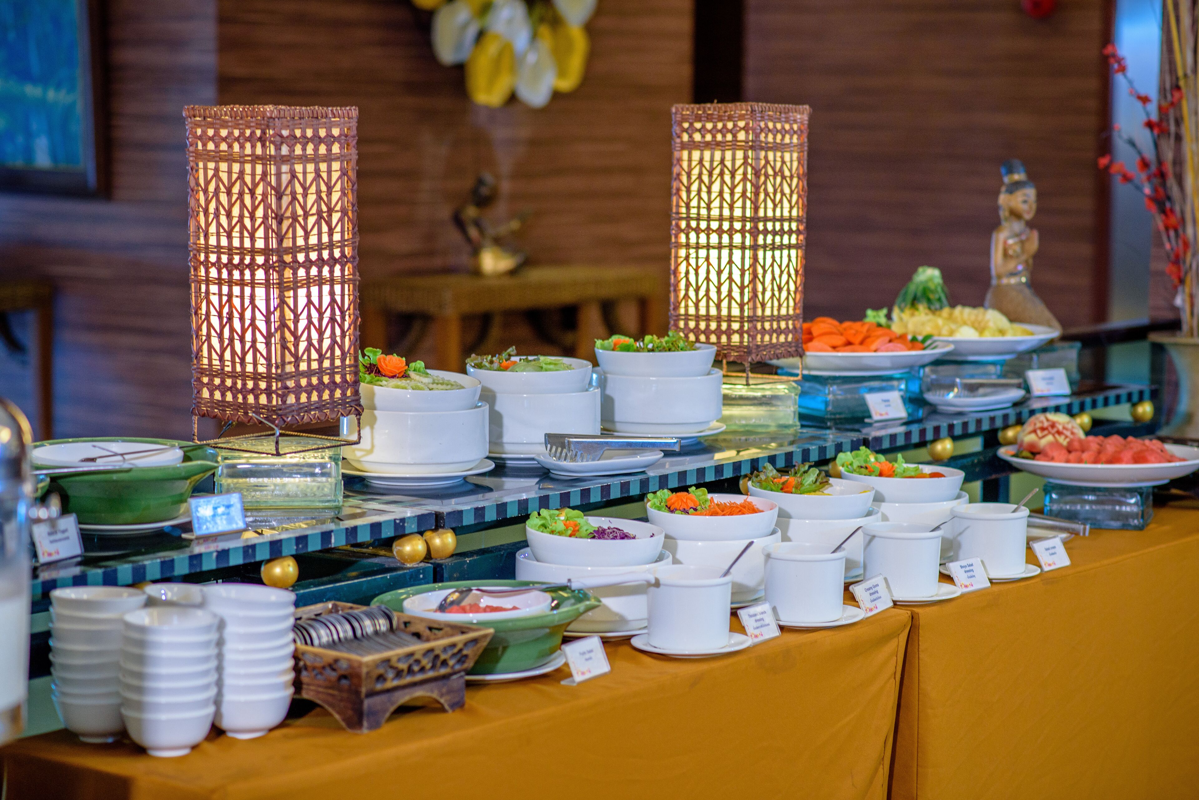 Una mesa de buffet con diversos platos y una lámpara decorativa.