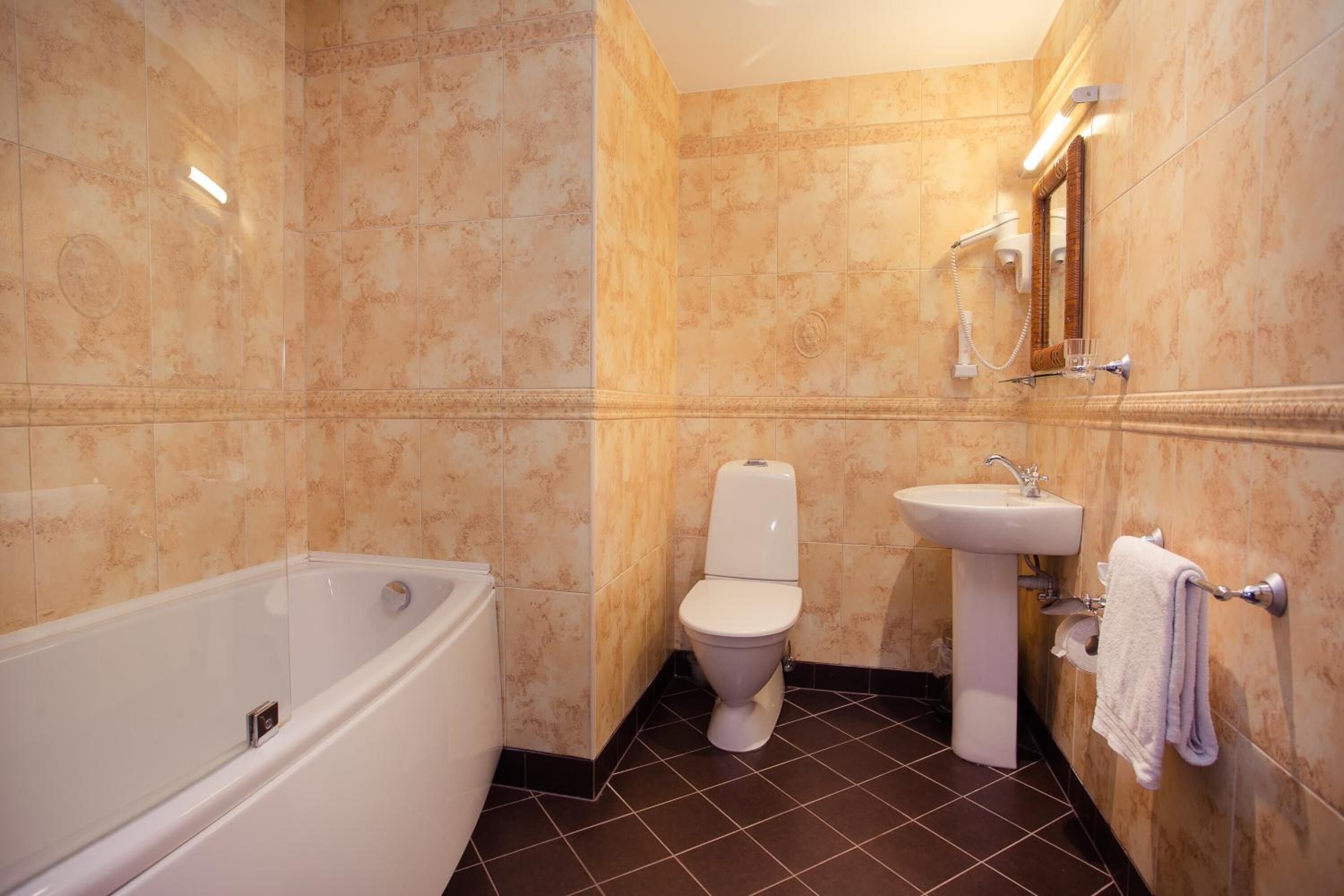 A bathroom with a bathtub, toilet, and sink.