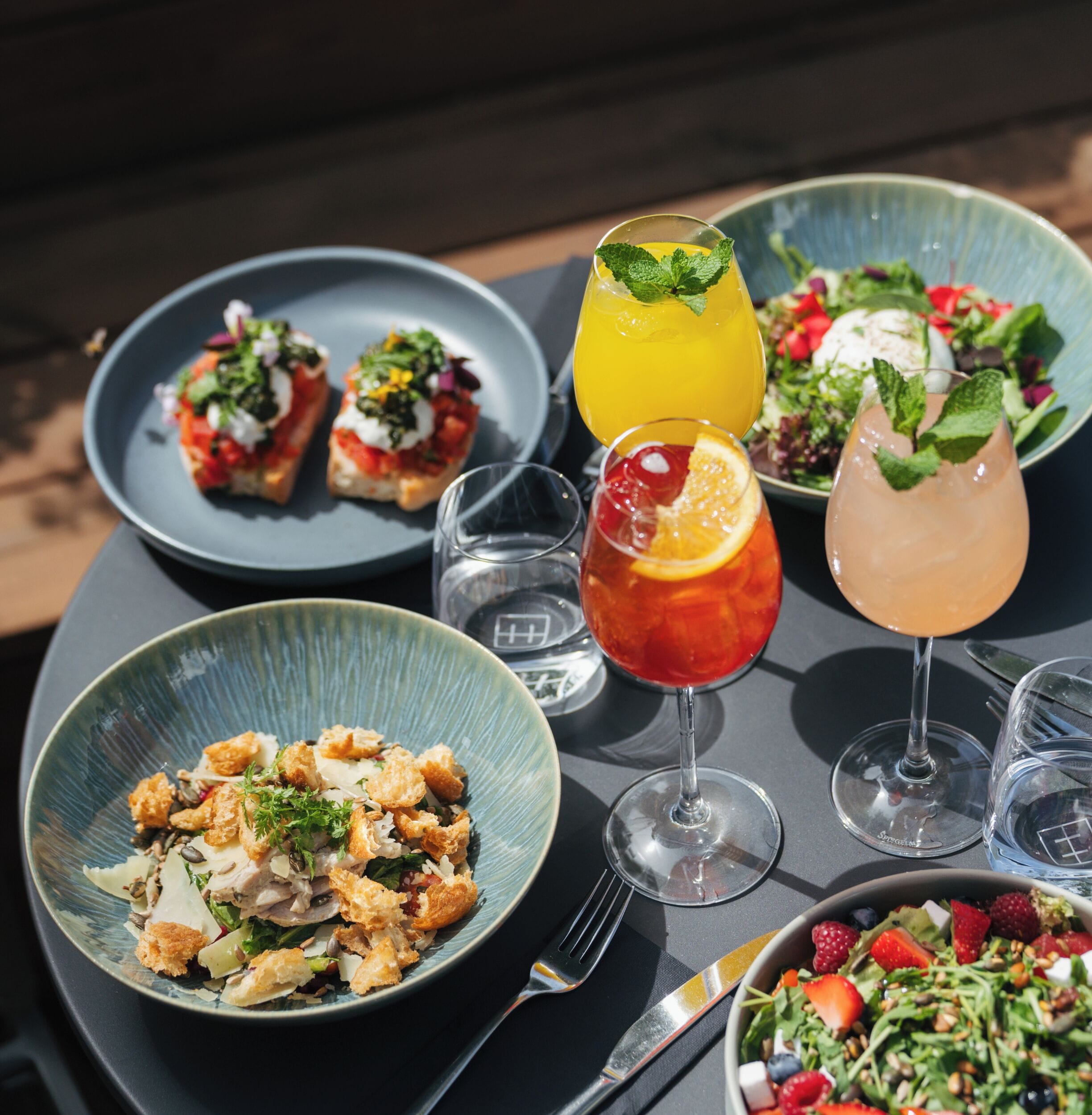 A table with various dishes, drinks, and dining utensils.