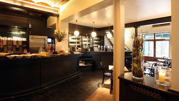 A restaurant with a brick ceiling, a bar area with a counter, and a seating area with tables and chairs. - Hotel De Groene Hendrickx (Hasselt)