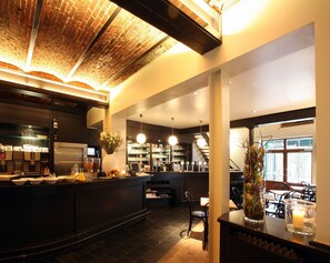 A restaurant with a brick ceiling, a bar area with a counter, and a seating area with tables and chairs. - Hotel De Groene Hendrickx (Hasselt)