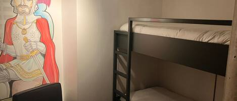 A bunk bed room with a mural on the wall.