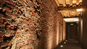 A narrow hallway with exposed brick walls and wooden beams on the ceiling. - Hotel De Groene Hendrickx (Hasselt)