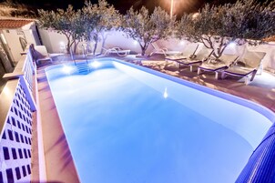 Una piscina al aire libre de temporada, sombrillas