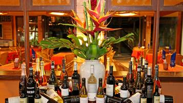 A table with various wine bottles and a decorative plant in the center.