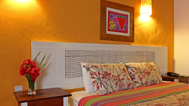 A bedroom with a bed, bedside table, lamp, and a framed picture on the wall. - Sobrado da Vila Hotel (Mata de São João)
