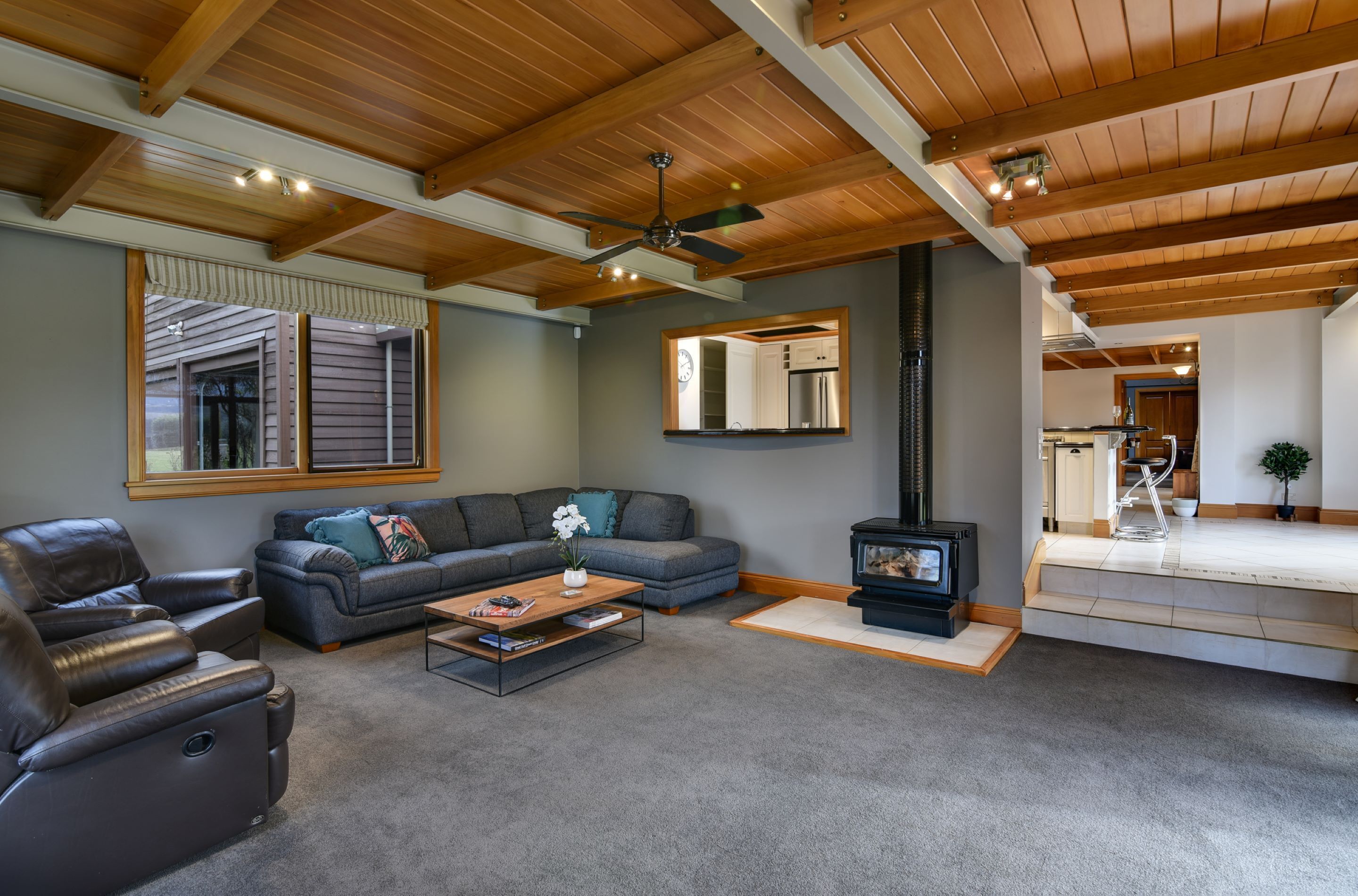 A living room with a sectional sofa, leather recliner, and a fireplace.