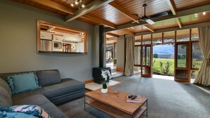 A modern living room with a sofa, coffee table, and a fireplace. - Manata Lodge (Lower Shotover)