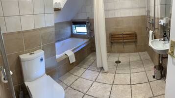 A bathroom with a bathtub, toilet, sink, and shower.