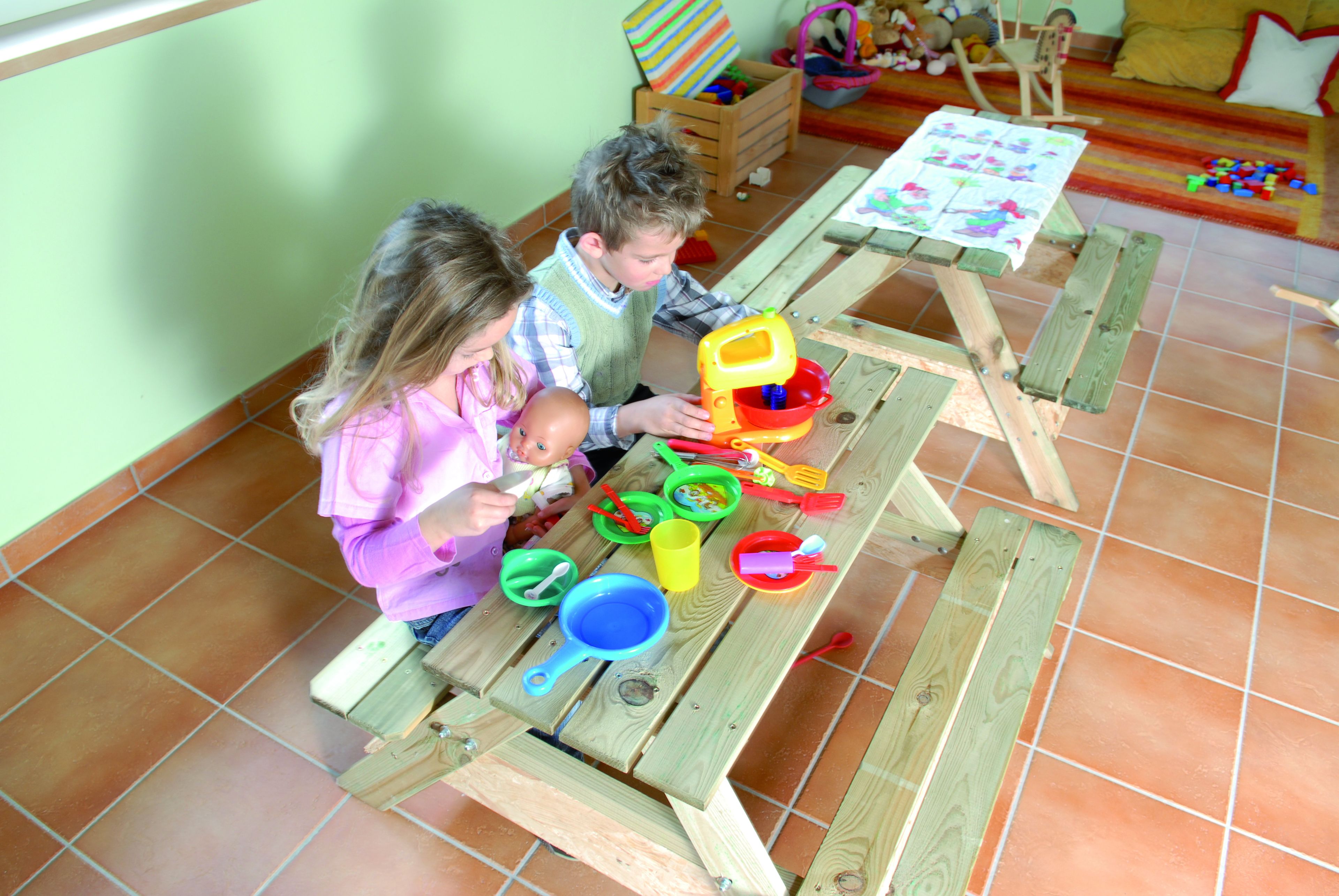 Une table en bois avec des jouets pour enfants et un tableau.
