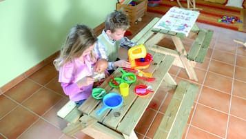 A wooden table with children's toys and a painting.