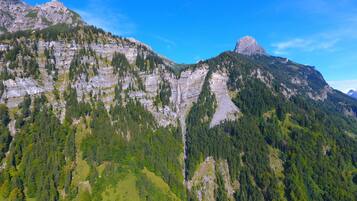 Un paisaje montañoso con densos bosques y acantilados rocosos.