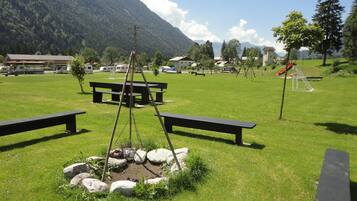 Un'area picnic con panchine e un braciere, circondata da rocce.