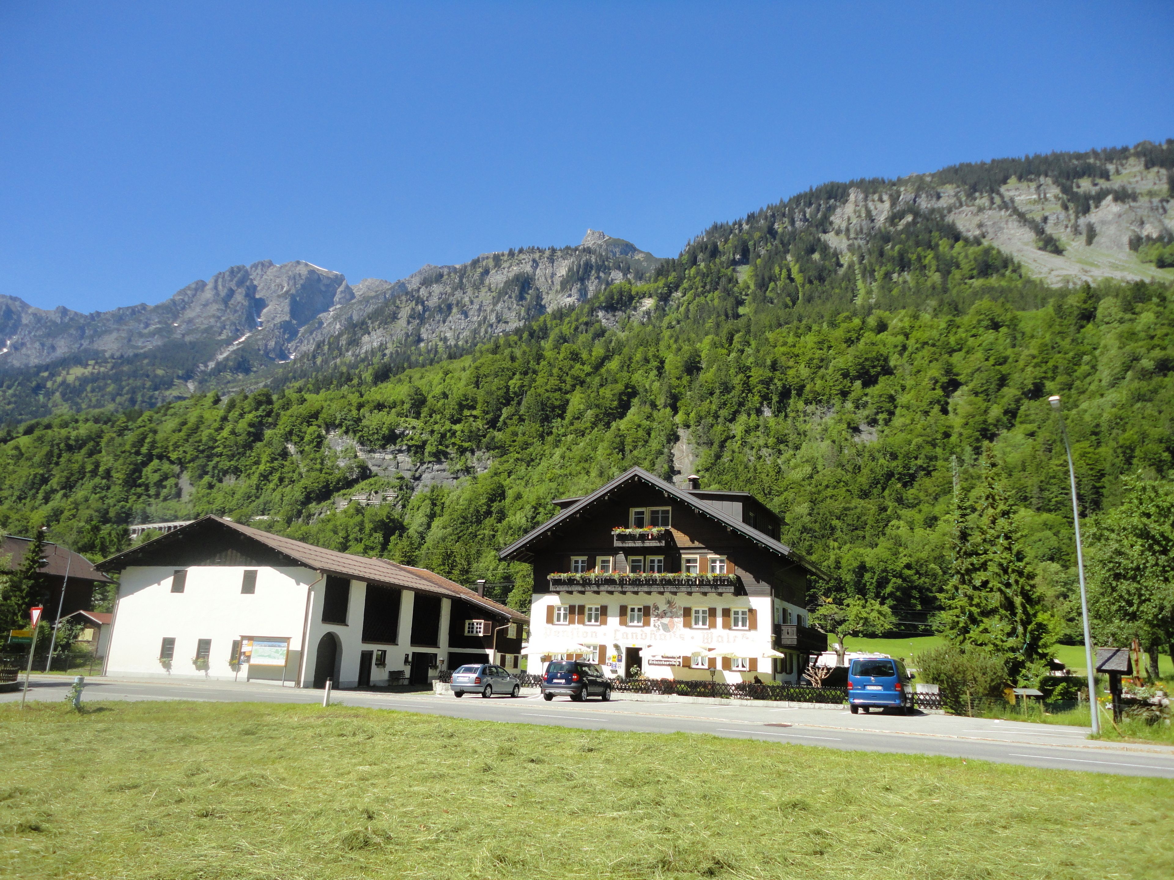 A mountain lodge with a large balcony and a sign indicating it is a restaurant.