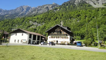 A mountain lodge with a large balcony and a sign indicating it is a restaurant.