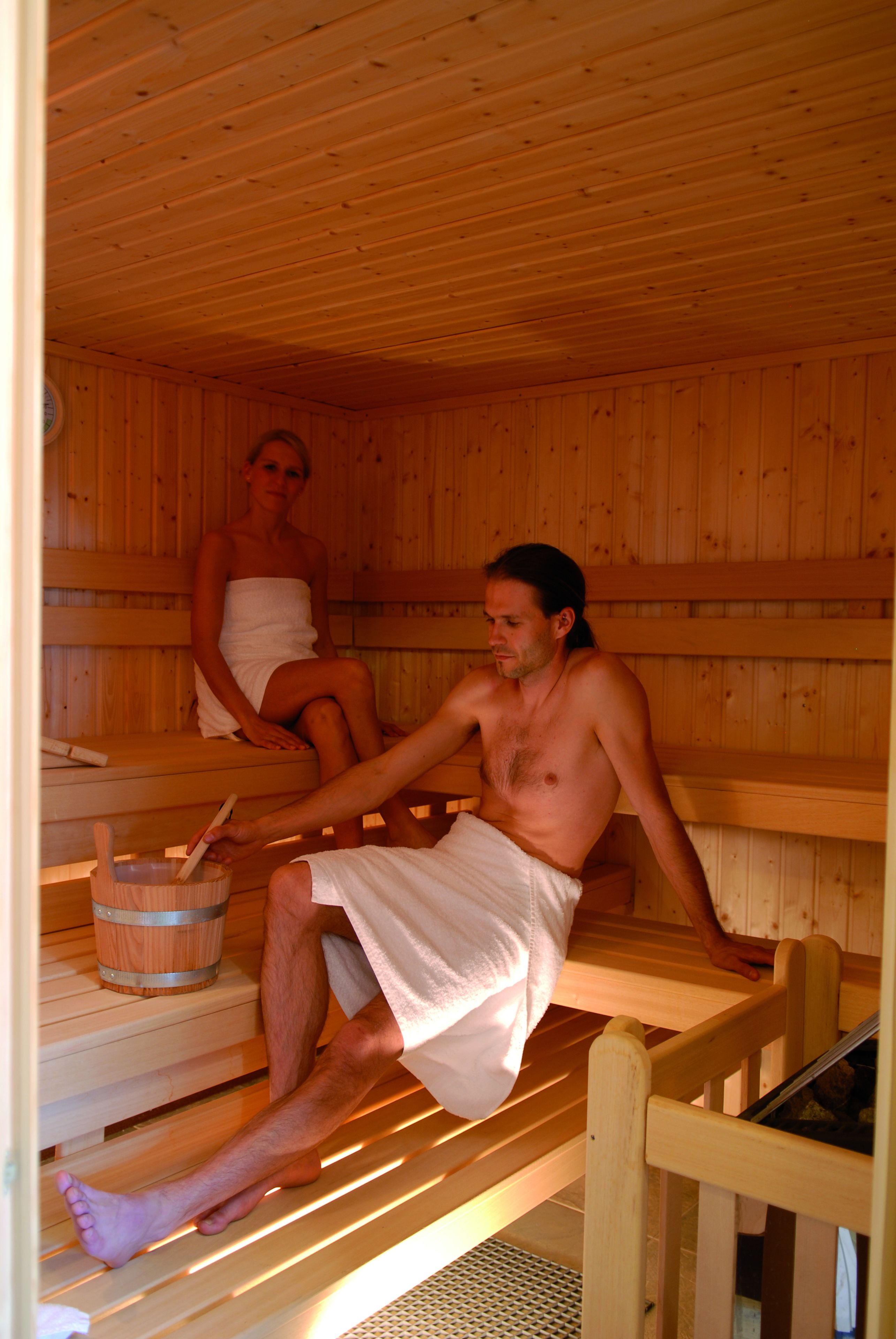 Sauna, jossa on puiset lauteet ja puinen ämpäri.
