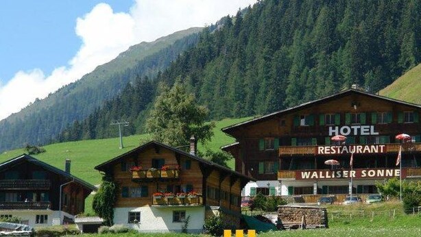 Un hotel en zona montañosa con un restaurante llamado "WALLISER SONNE".