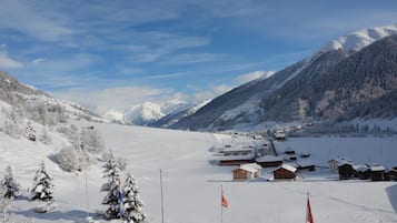 A snow-covered village with buildings and a mountain backdrop.
