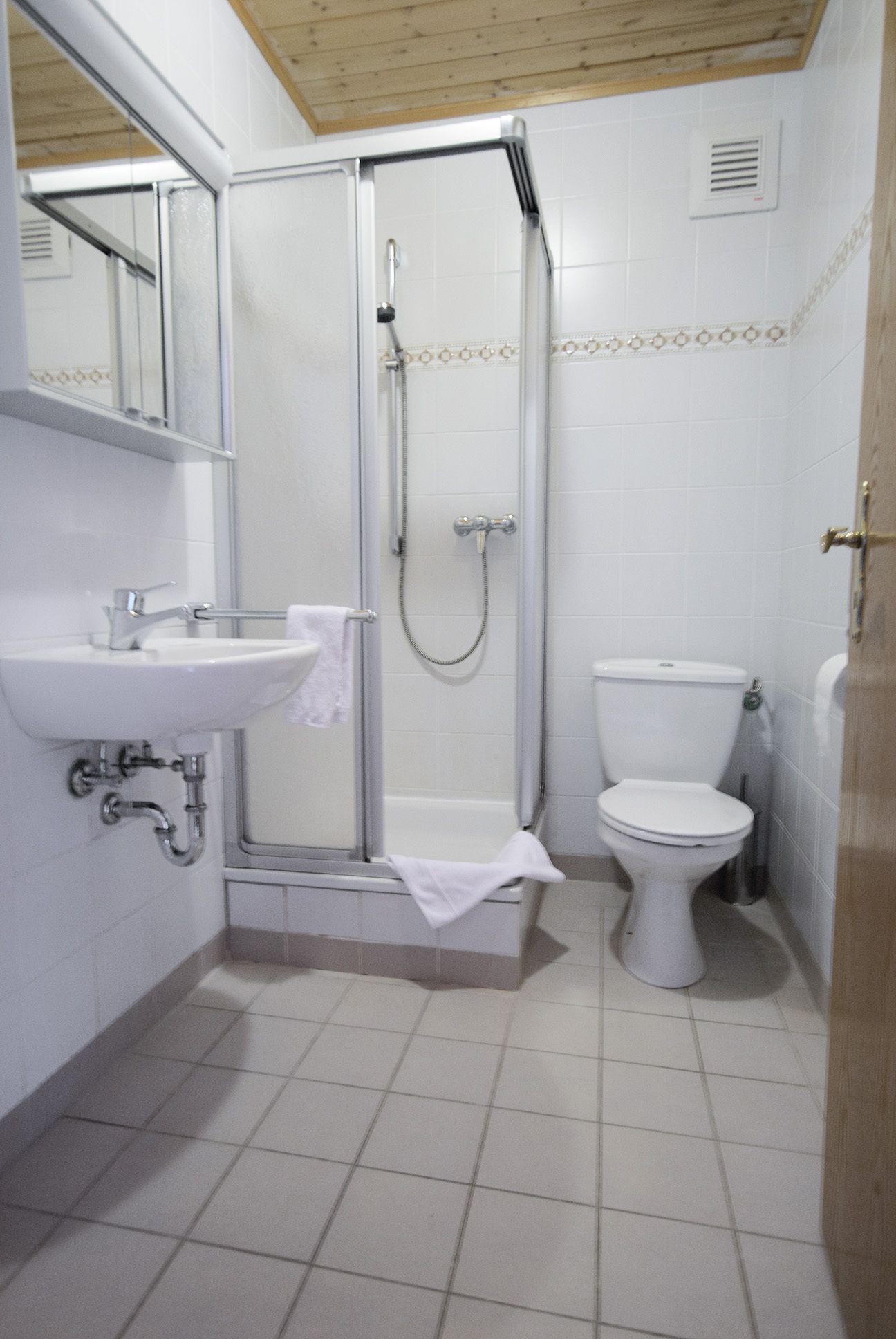 A bathroom with a shower, sink, and toilet.