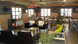 Un espacio de sala acogedor con chimenea, asientos cómodos y ventanas amplias.