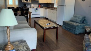 A compact living space with a kitchenette, a dining area, and a seating area. - Riverside Motel (Port Alberni)