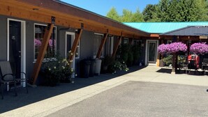 A building with a covered outdoor seating area and a sign that reads "OFFICE". - Riverside Motel (Port Alberni)