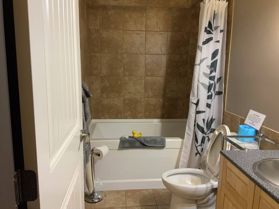Een badkamer met een bad, toilet en een douchegordijn.