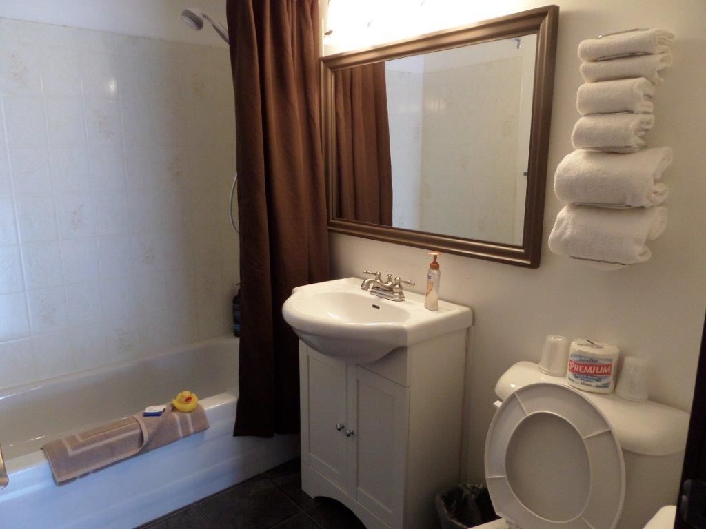 Ein Badezimmer mit einer Badewanne, einem Waschbecken, einer Toilette und einem Spiegel.
