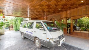 A white van parked under a wooden ceiling with a reception area visible in the background. - Lin Ratanak Angkor Hotel (Siem Reap)
