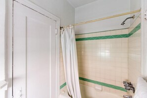 A bathroom with a shower curtain, a bathtub, and a toilet. - Hotel Del Flores (Beverly Hills)
