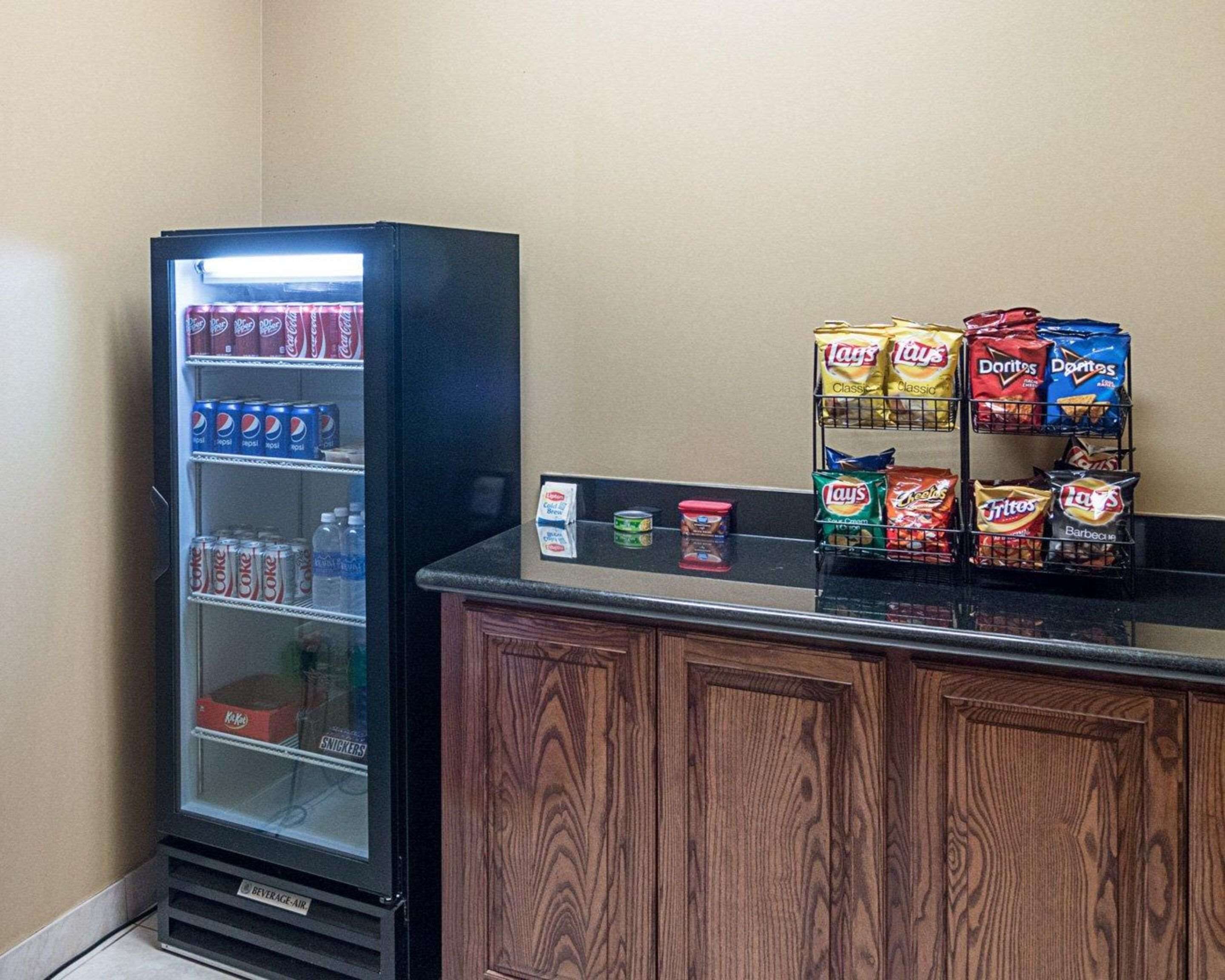 A vending machine with Pepsi and Coca-Cola, and a snack display with Lay's, Doritos, and other chips.
