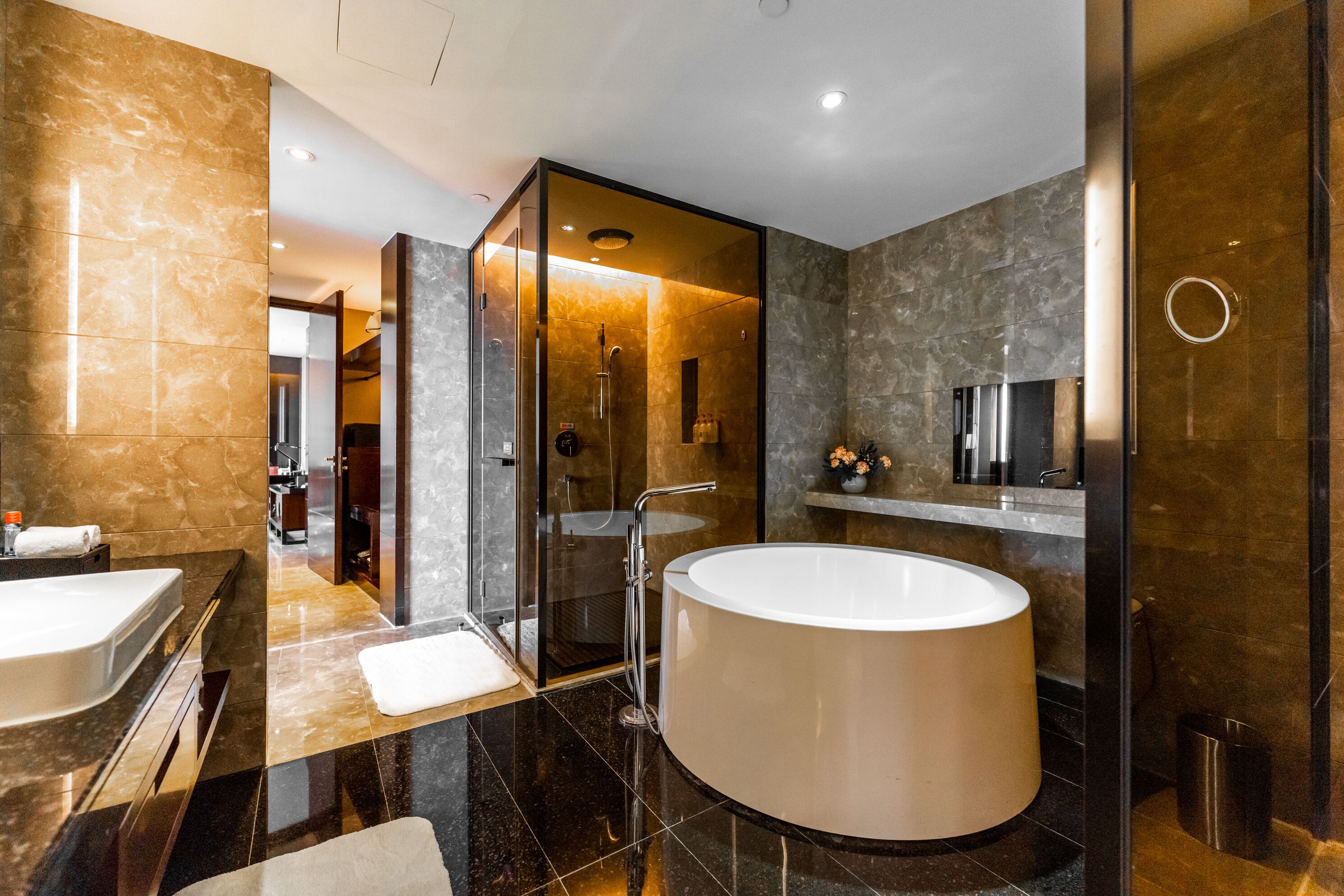 Un baño moderno con una bañera grande, ducha con cerramiento de vidrio y tocador con espejo.