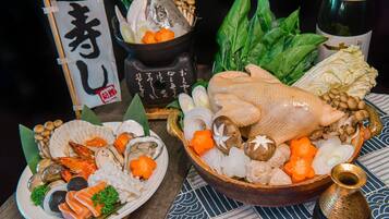 A variety of seafood and vegetables on a table, including a whole fish, shrimp, and mushrooms.