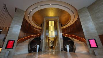 Een modern interieur met een centrale trap, gepolijste vloeren en een opvallend rond plafondontwerp.