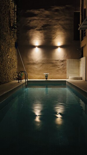 Una piscina al aire libre de temporada, sombrillas