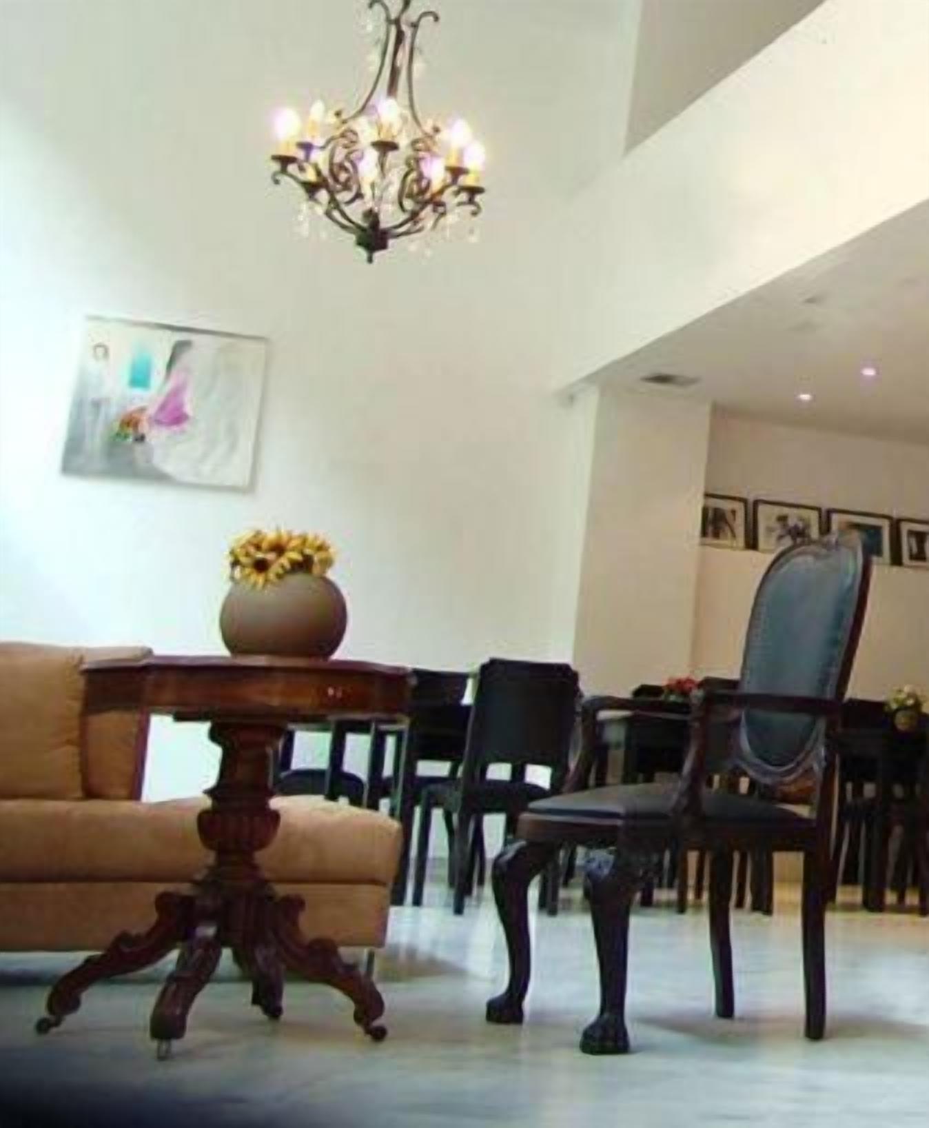 Un comedor con una mesa, sillas, una lámpara de araña y un cuadro en la pared.