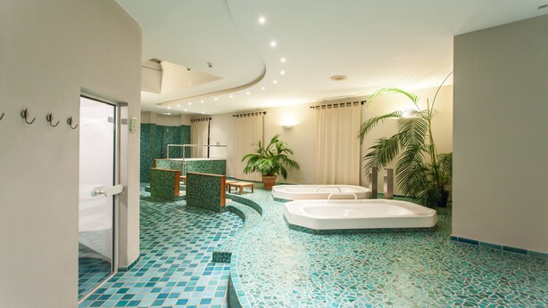 A modern bathroom with a mosaic floor, a shower area, and two hot tubs. - Hotel Deutscher Hof (Trier)