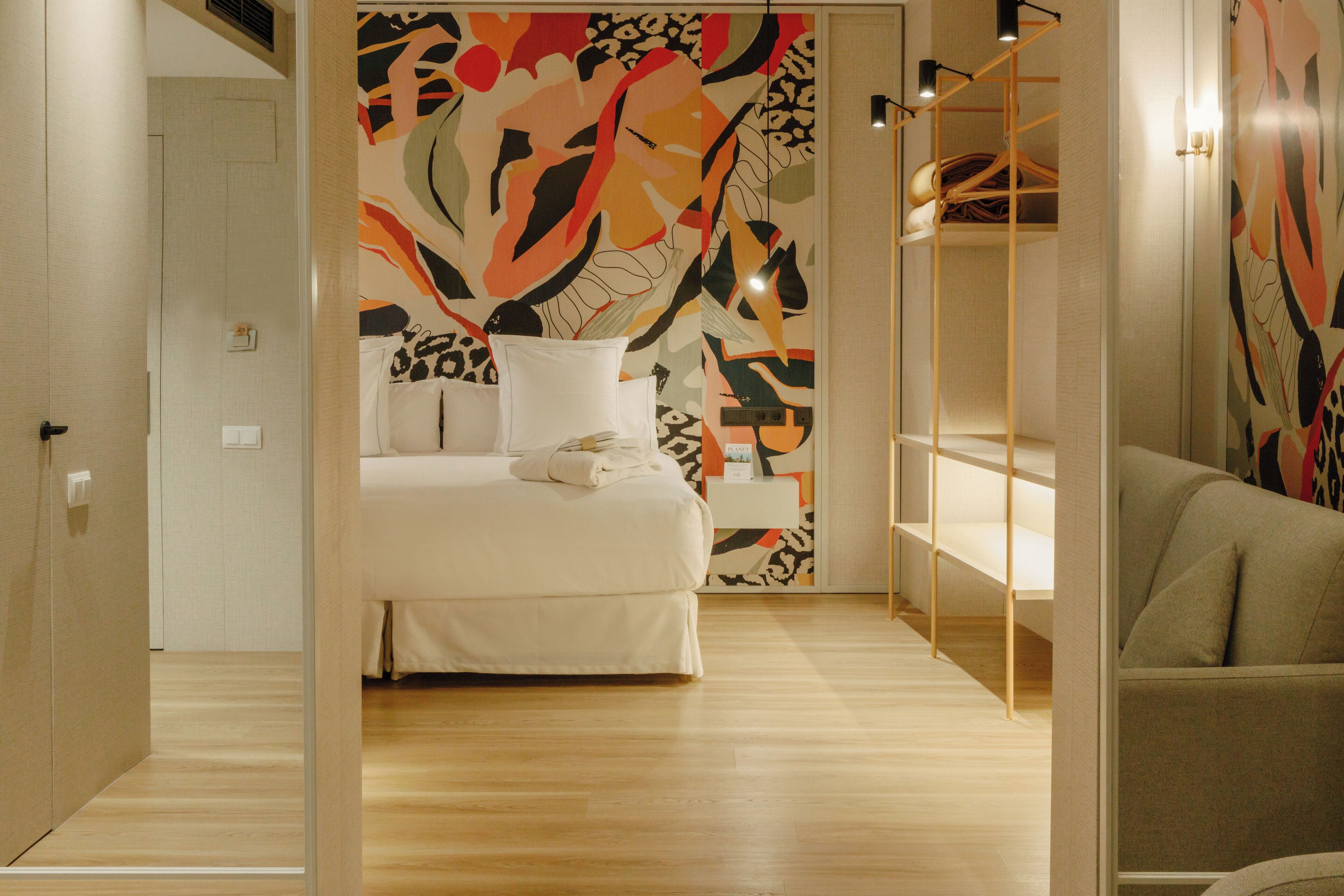 Ein modernes Schlafzimmer mit Bett, Schrank und einer Couch.