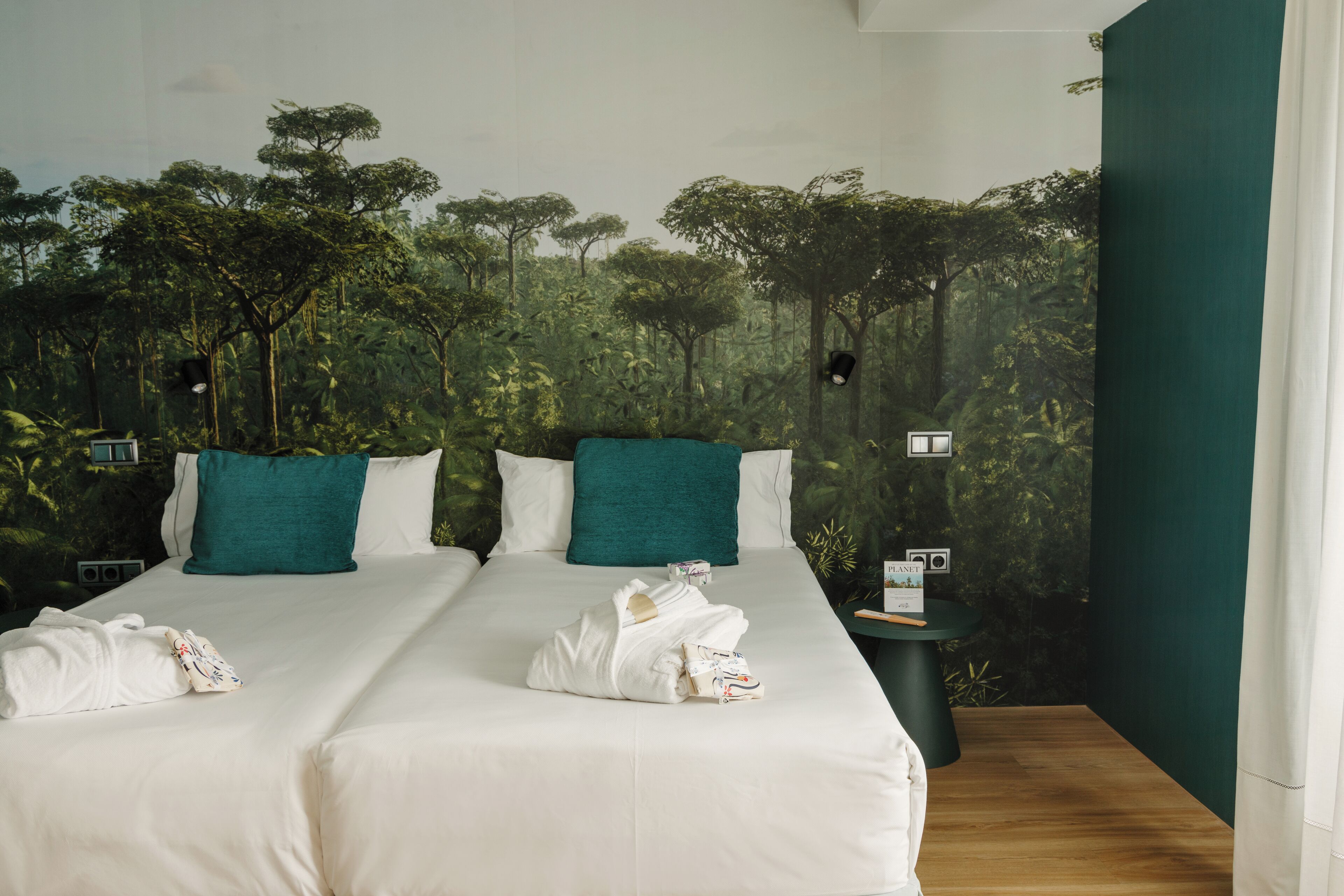 A hotel room with a large bed, two pillows, and a nightstand with a lamp.