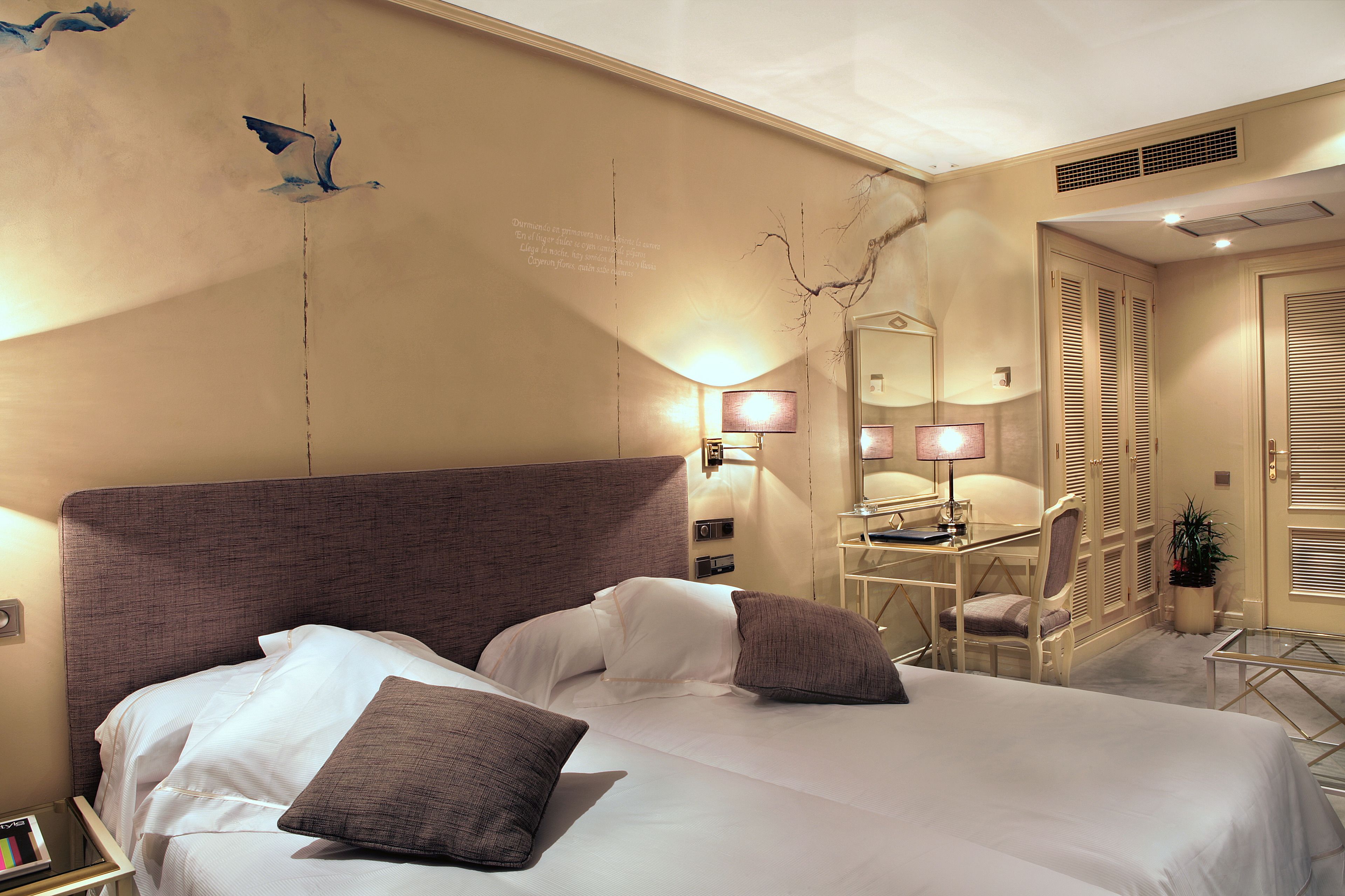 Een hotelkamer met twee bedden, een bureau, een stoel en een spiegel.